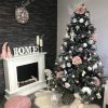 Krásna fotka zasneženého vianočného 3D stromčeka ozdobeného ružovkastými ozdobami. Pod stromčekom sa nachádza biela podložka pod stromček .