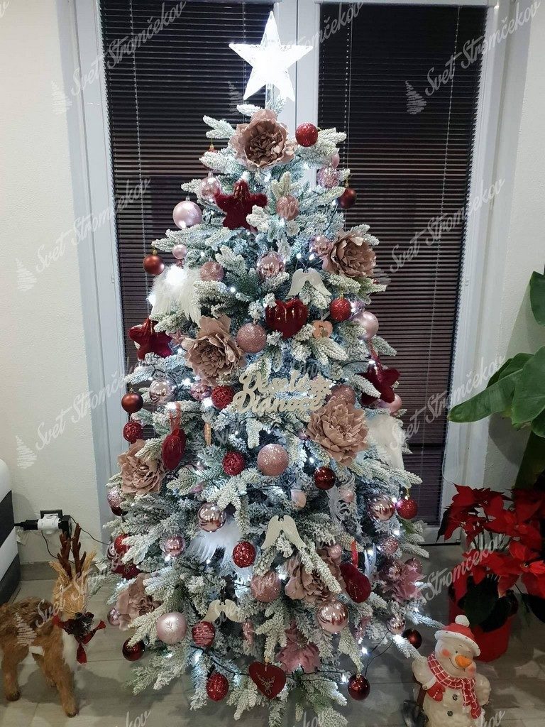 Ozdobený biely vianočný stromček do červeno strieborných farieb .