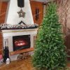 Vianočný stromček vedľa krbu. Krb je ozdobený vianočnými dekoráciami.