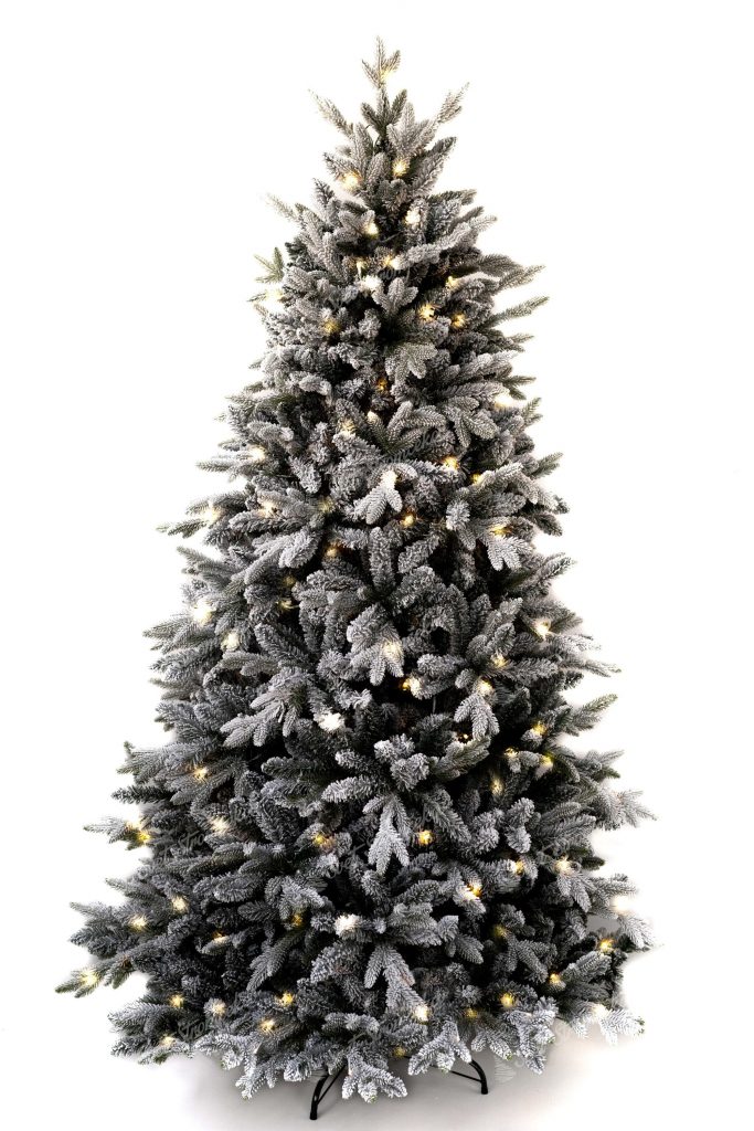 Biely vianočný stromček postavený na kovovom stojane. Celý stromček je vysvietený s LED svetielkami.