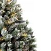 Detailná fotka zasnežených vetvičiek umelého vianočného stromčeka .