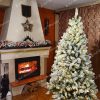Biely, celo zasnežený stromček s LED osvetlením v obývačke na Vianoce.