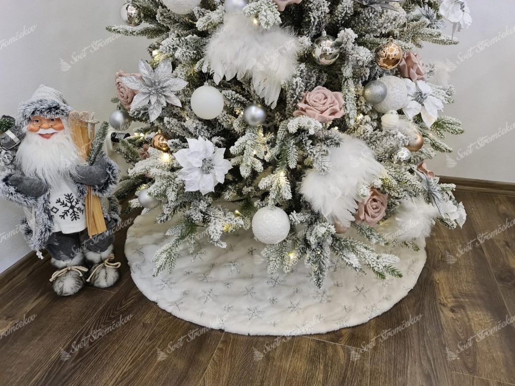 Biely koberec pod stromček so striebornými vločkami 122cm pod 210cm vianočným stromčekom. Koberec bielej farby má na sebe strieborné vločky z flitrov.