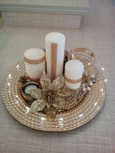 Adventný veniec na tanieri. Biele sviečky uložené na zlatom tanieri s ozdobami.