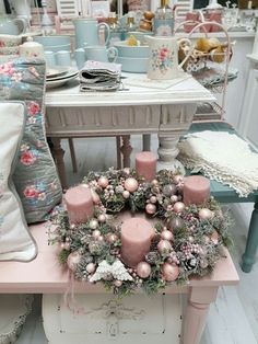 Ružový adventný veniec. Bohato vyzdobený ozdobami a guľami s ružovými sviečkami.