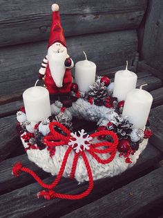 Červený adventný veniec s bielymi sviečkami a dekoráciou Mikuláša