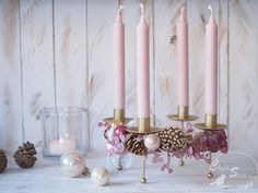 Ružový adventný veniec. Štyri dlhé ružové sviečky na zlatých stojanoch, ozdobených ružovými ozdobami.