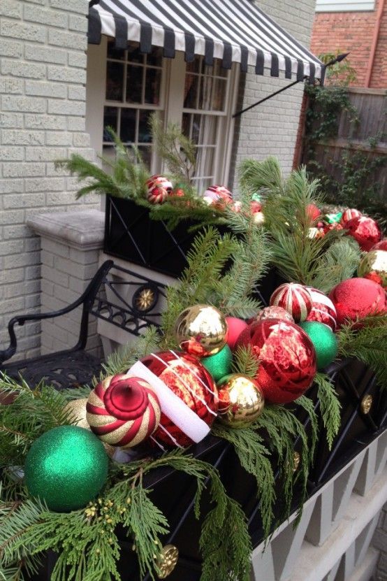 Vianočná výzdoba na balkóne, zelená girlanda s červenými, zelenými a zlatými vianočnými guľami
