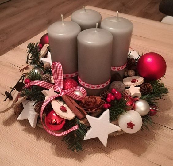 Vianočný veniec na stôl s červeno bielymi ozdobami a šedými sviečkami