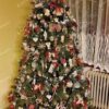 Tmavoezelený umelý vianočný stromček, ozdobený drevenými a slamenými ozdobami
