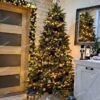 Bledozelený umelý vianočný stromček, husto ozdobený zlatými ozdobami, v obývačke