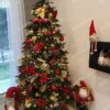 Zelený umelý vianočný stromček, ozdobený červeno-zlatými ozdobami