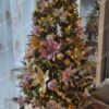 Umelý vianočný stromček so zelenými vetvičkami, ozdobný v glamour štýle, zlato-ružovými ozdobami a teplým bielym osvetlením
