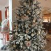 Umelý vianočný stromček so zasneženými vetvičkami, ozdobený zlato-bielo-ružovými ozdobami, s bielym koberčekom pod stromček.