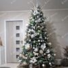 Umelý vianočný stromček so strieborno-zelenými vetvičkami, ozdobený bielo-zlatými a drevenými ozdobami.