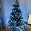 Umelý vianočný stromček s bielo-zlatými ozdobami v rohu obývačky