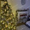Umelý klasický vianočný stromček so striebornou aplikáciou na konci vetvičiek a drobnými kryštálikmi ľadu, ozdobený bielo-zlatými ozdobami a teplým bielym osvetlením