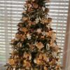 Umelý vianočný stromček ozdobený zlatými ozdobami s teplým bielym vianočmým osvtelením