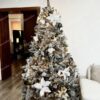 Umelý zasnežený vianočný stromček s bielo-zlatými ozdobami a vianočnými ružami