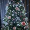 Umelý vianočný stromček s bielo-ružovými ozdobami a bielym osvetlením.