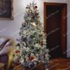 Umelý zasnežený vianočný stromček s bielo-zlatými ozdobami a s bielym osvetlením.