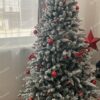 Umelý vianočný stromček zasnežený s červenými ozdobami s LED osvetlením