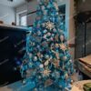 Ozdobený vianočný stromček s bielo-striebornými ozdobami a modrým osvetlením v obývačke