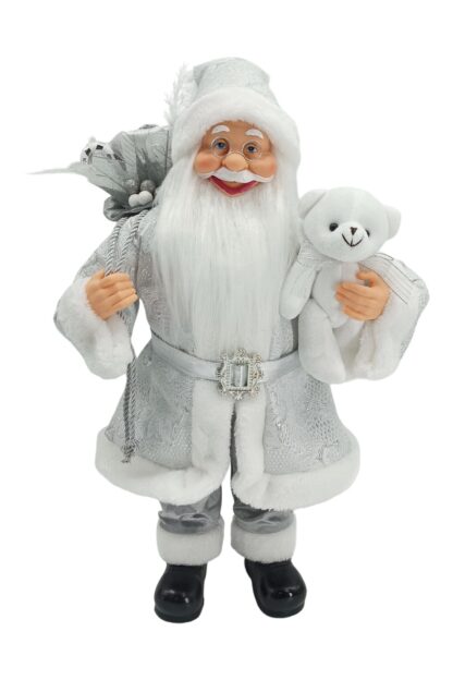 Dekorácia Santa Claus strieborný 60cm je oblečený v striebornom kabátiku s bielym lemom. Opásaný je strieborným opaskom. Na nohách má obuté čierne topánky. Má hustú bielu bradu a okuliare. v ruke drží bieleho plyšového medveďa ana pleci má zavesný batoh s darčekmi.