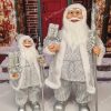 Vianočná dekorácia Mikuláš ľadový, oblečený má strieborno-biely kabát a v ruke drží darčeky