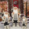 Vianočná dekorácia Mikuláš sivý, oblečený má sivý kabát s kožušinou a v ruke drží lyže
