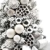 Zasnežený malý vianočný stromček so striebornými a bielymi vianočnými guľami a striebornou mašľou.