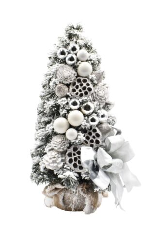 Zasnežený malý vianočný stromček so striebornými a bielymi vianočnými guľami a striebornou mašľou.