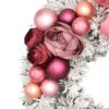 Zasnežený vianočný veniec na dvere s tmavo ružovými vianočnými guľami a ružovou mašľou.