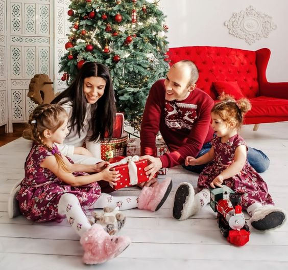 rodina s deťmi pri rozbaľovaní vianočných darčekov