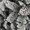 Detail stromčeka Umelý vianočný stromček 3D Smrek Polárny. Stromček je husto zasnežený a vetvičky ozdobené šiškami.