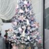 Umelý vianočný stromček Smrek Biely 220cm, stromček má husto zasnežené vetvičky a je ozdobený ružovými ozdobami