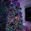 Umelý vianočný stromček Smrek Severský 270cm, stromček má vetvičky husto pokyrté umelým snehom a je ozdobený červeno-zlatými ozdobami a farebným osvetlením
