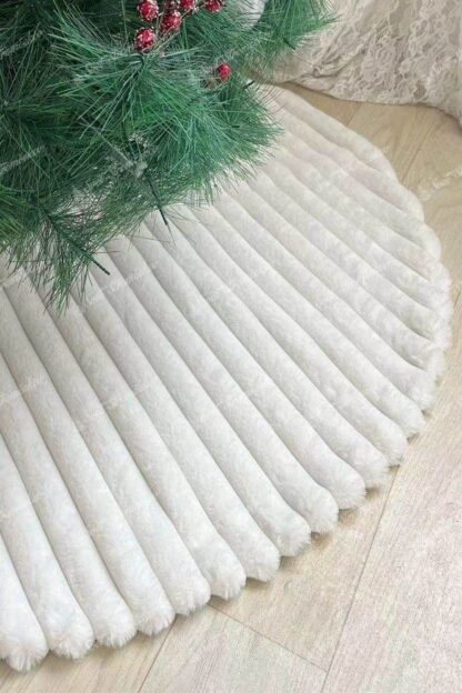 Biely pruhovaný koberec pod stromček je bielej farby a má pruhovaný vzor
